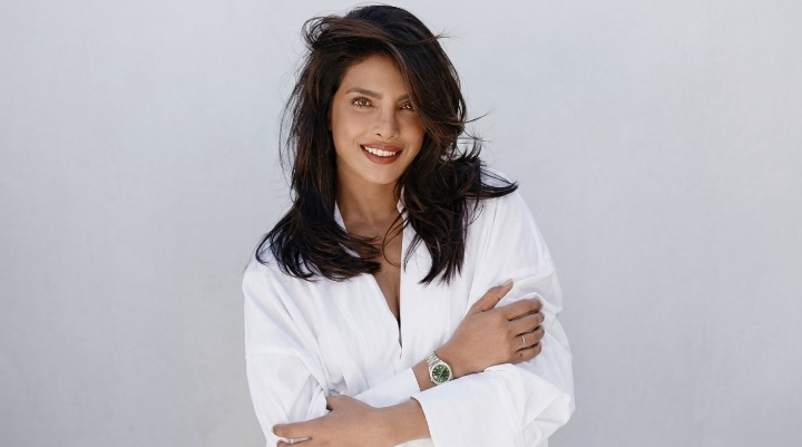 Smiling woman posing in white wearing Rolex